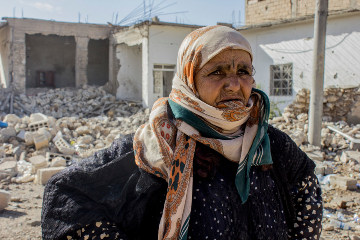 Amneh from Al Mishlab, east of Raqqa city. She fled Al Mishlab with her family eight months ago. They moved five times before coming back as the front lines kept getting closer to their location. They came back to Al Mishlab to check their houses. Most of their houses are destroyed. She is standing in front of her grandchild house that was fully destroyed. She said "we will try to rebuild our houses but there is still no services in the area yet."