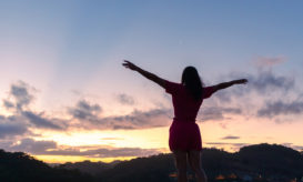 γυναίκα σε κορυφή με τα χέρια ανοιχτά